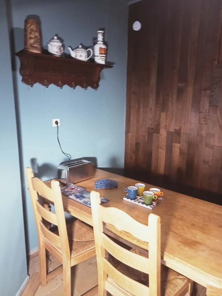 Table en bois et chaises paillées du coin repas du gîte L’Intemporel