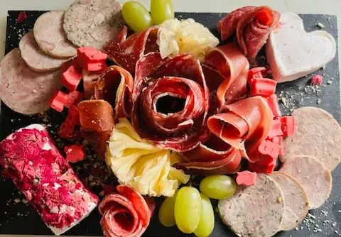 Plateau apéritif : roses de charcuterie, fromages et raisin