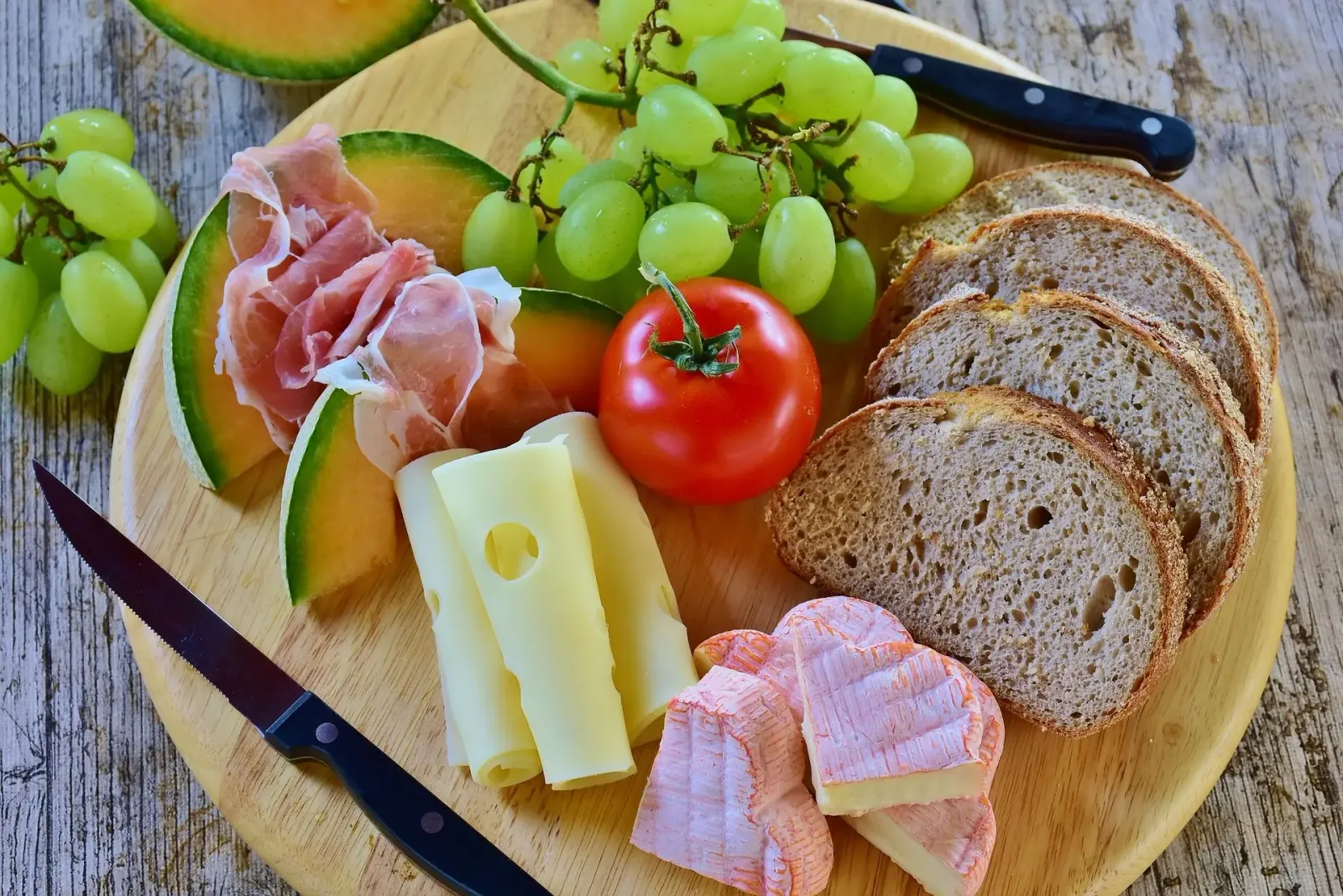 Planche apéritive : charcuterie, fromages, melon et raisin